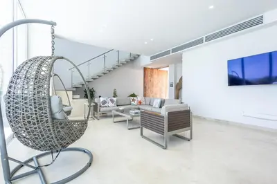a living room with a chair and a swing at Brand new 4BR Villa at Calablanca in Cartagena de Indias