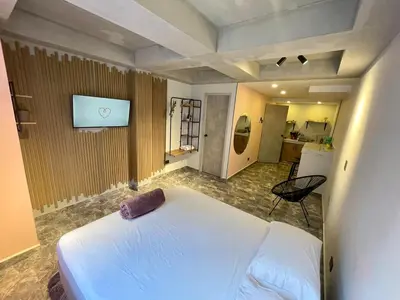 a bedroom with a white bed and a tv on the wall at Almería Apt, Stylish Modern Studio Near Centro in Cartagena de Indias