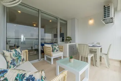 a living room with a couch and a table at CB Lujoso Apartasuit -Vista al mar-linda piscina-cerca al Aeropuerto in Cartagena de Indias