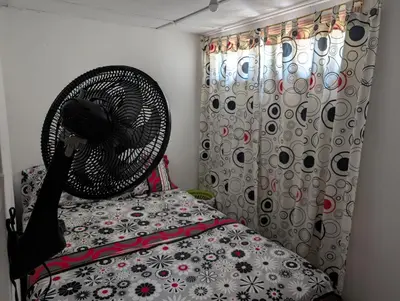 a bedroom with a fan sitting on a bed at English power Exotic point in Barranquilla