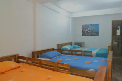 a bedroom with two beds with blue sheets at Mango Tree Island 420 in Tierra Bomba