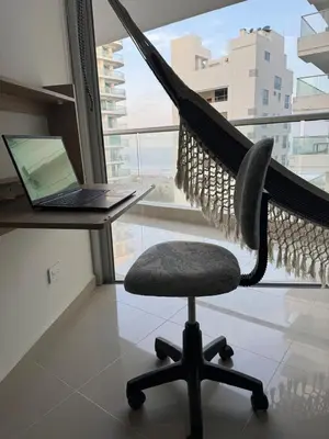 a hammock chair sitting in front of a desk with a laptop at Apartamento en Morros in Cartagena de Indias