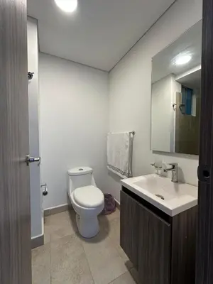 a bathroom with a toilet and a sink and a mirror at Apartamento cómodo en Conjunto residencial Castelo Cartagena in Cartagena de Indias