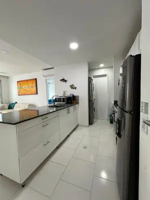 a kitchen with white cabinets and a stainless steel refrigerator at Exclusivo Apartamento con playa y piscinas Morros Cartagena in Cartagena de Indias