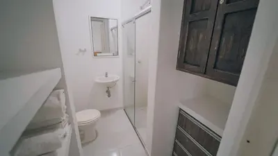 a white bathroom with a toilet and a sink at Caribe Familiar 504 in Coveñas