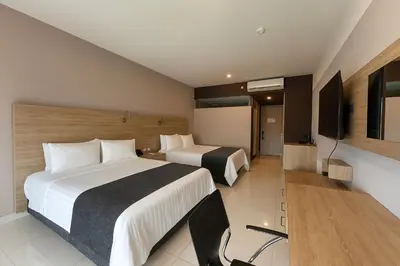 a hotel room with two beds and a television at Sky Collection Lifestyle Hotel & Suites Barranquilla in Barranquilla