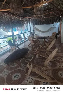 a room with a bunch of chairs and a hammock at Hotel donde Tito in Tolú