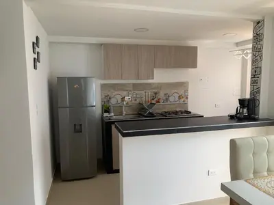 a kitchen with a refrigerator and a counter top at Prada Caribe 303 in Coveñas