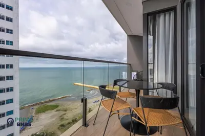 a balcony with a table and chairs and a view of the ocean at Beach Front - Luxury High Rise - Dubai Style in Cartagena de Indias