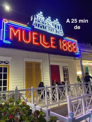 people sitting outside of a motel with a neon sign at Wow que vista!! Frente Ecoparque 7min CC Buenavista in Puerto Colombia