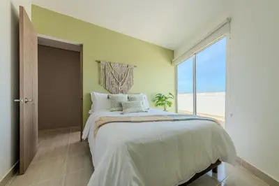 a bedroom with a bed and a large window at Condominio Moderno nuevo Trevi in Cartagena de Indias