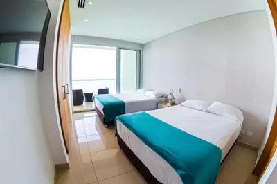 a hotel room with two beds and a balcony at luxury Aparment Ocean view H2 condominium apto 2105 in Cartagena de Indias