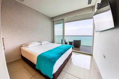 a bedroom with a bed and a view of the ocean at luxury Aparment Ocean view H2 condominium apto 2105 in Cartagena de Indias