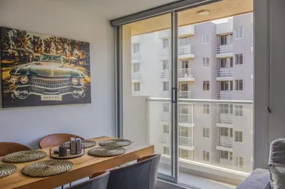 a dining room with a table and a large window at New modern apartment in Barranquilla