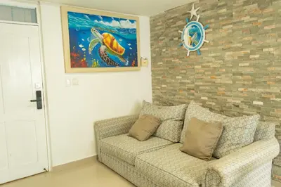 a living room with a couch and a painting at Inca Caribe 302 in Coveñas