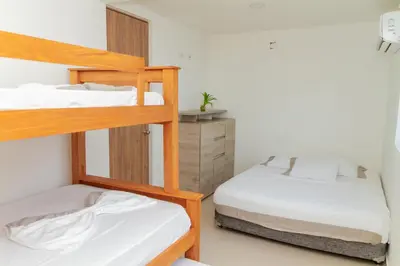 two bunk beds in a small room with a bed at Raíces Caribe 503 in Coveñas