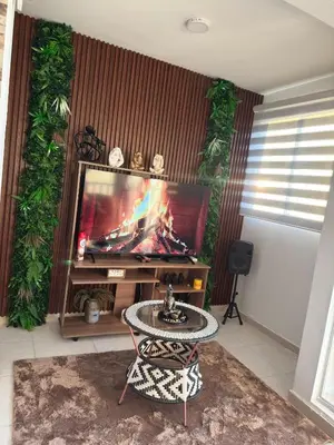 a living room with a tv and a table with a fireplace at ÁME Living in Cartagena de Indias