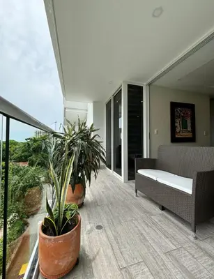 a porch with plants and a couch on a balcony at 1 bedroom luxury apartment with private jaccuzi in Cartagena de Indias