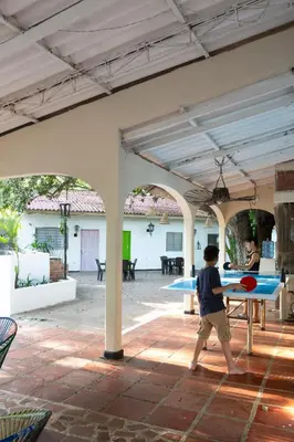 a boy playing with a ping pong table in a patio at Hotel Villa Ivel in Turbaco