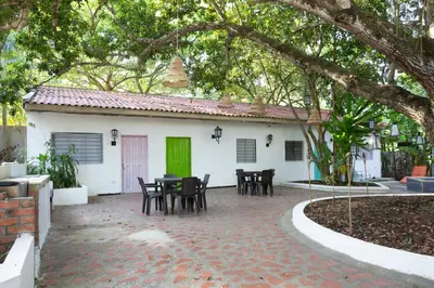a patio in front of a white house with a green door at Hotel Villa Ivel in Turbaco