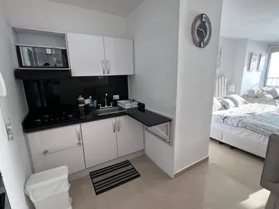 a white kitchen with a sink and a bed at Apartamento Cristoforo Colombo in Cartagena de Indias