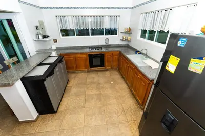 a kitchen with a black refrigerator and a sink at Casa La Altamar in Coveñas