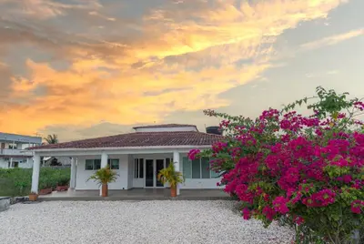 a white house with pink flowers in front of it at Casa La Altamar in Coveñas