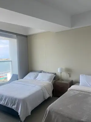 two beds in a hotel room with a window at Luxury Ocean View - Bocagrande in Cartagena de Indias