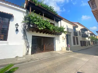 a white building with a gate and plants on it at Apartamento en el centro historico de Cartagena in Cartagena de Indias