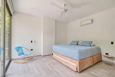 a bedroom with a bed and a blue chair at Casa BaruGrande in Cartagena de Indias