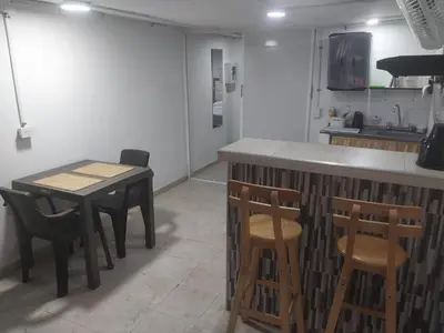 a kitchen with a table and two chairs and a counter at Alojamiento independiente, sencillo y acogedor in Barranquilla