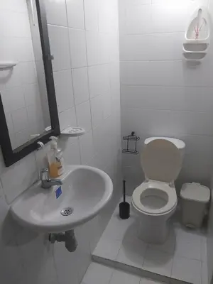 a white bathroom with a toilet and a sink at Alojamiento independiente, sencillo y acogedor in Barranquilla
