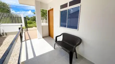 a black chair sitting on the porch of a house at Habitación Manglares 103 in Coveñas