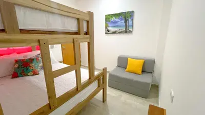 a bedroom with a bunk bed and a couch at Habitación Manglares 103 in Coveñas