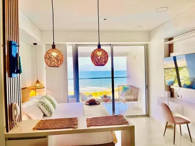 a bedroom with a table and a view of the ocean at Beachfront Apartment - Pool - Jacuzzi - Wi-Fi in Cartagena de Indias