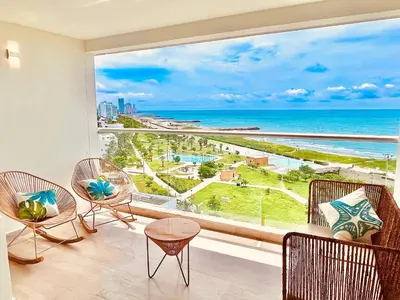 a room with a large window with a view of the ocean at Beachfront Apartment - Pool - Jacuzzi - Wi-Fi in Cartagena de Indias