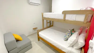 a small room with two bunk beds and a chair at Habitacion Manglares 101 in Coveñas
