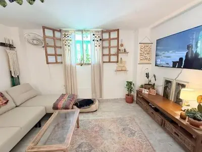 a living room with a white couch and a tv at Tropical Nomad Hub - Pool - Super Fast Wi-Fi in Santa Veronica