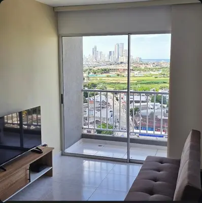 a living room with a large window with a view of a city at Hermoso apartamento cerca a las playas de Marbella in Cartagena de Indias