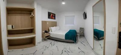 a hotel room with a bed and a mirror at Hotel Serenity Inn in Cartagena de Indias