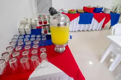 a table with a bottle of orange juice and soda cans at Hotel Serenity Inn in Cartagena de Indias
