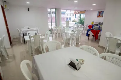 a dining room with white tables and white chairs at Hotel Serenity Inn in Cartagena de Indias
