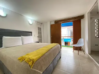 a bedroom with a bed with a yellow blanket on it at Casa Trinidad Getsemaní Hotel in Cartagena de Indias