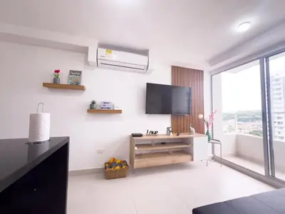 a white living room with a flat screen tv on the wall at Family apartment in Cartagena 3 bedrooms 2 bathrooms in Cartagena de Indias