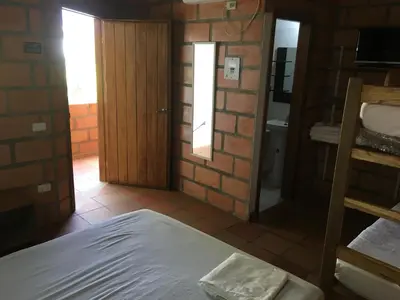 a bedroom with a bed and a door to a bathroom at Hotel Pizzeria Opera Tolú in Tolú