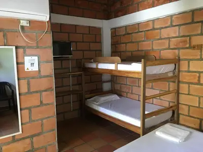 a room with bunk beds in a brick wall at Hotel Pizzeria Opera Tolú in Tolú
