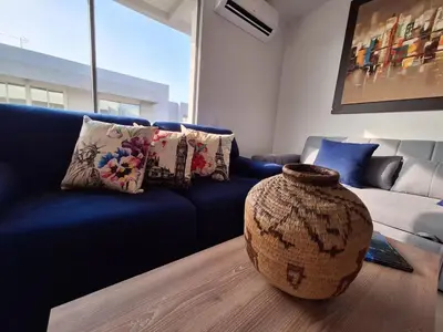 a living room with a blue couch and a large vase at Cartagena zona norte playa uso exclusivo in Cartagena de Indias
