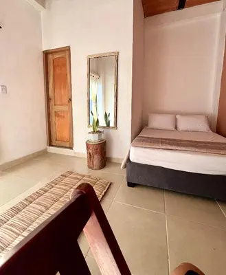 a bedroom with a bed and a mirror at Isla Rosa Coveñas - Alojamiento in Coveñitas