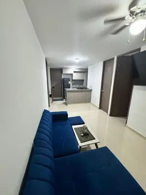 a living room with a blue couch and a table at Apartamento moderno en zona norte exclusiva in Barranquilla