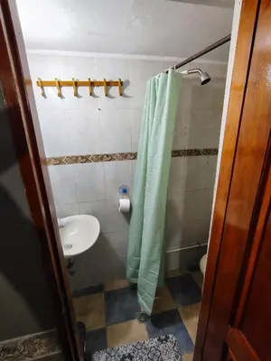 a bathroom with a green shower curtain and a sink at Tiny Room con Ventilador in Cartagena de Indias